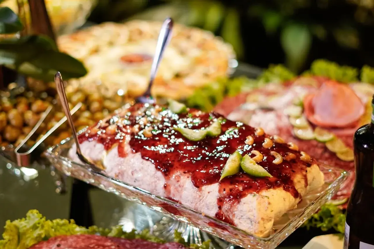 Mesa de buffet com frios, saladas e pratos variados.