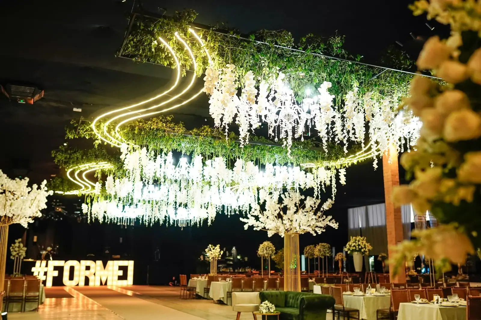 Decoração aérea de formatura com flores suspensas, luzes e o letreiro #FORMEI.